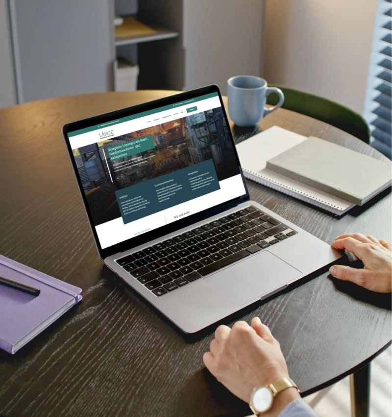 Auf dem Bild wird ein Bürotisch gezeigt auf dem ein Laptop steht. Auf dem Screen ist die Webseitenstartseite zu sehen. Webentwicklung gehört zu den Kompetenzen von BEPOINT Medien.