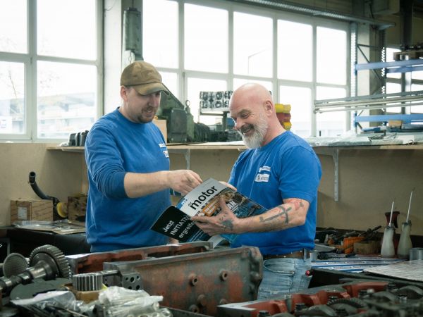 Mitarbeiter Motoren Michaelis lesen das Magzin "der motor"